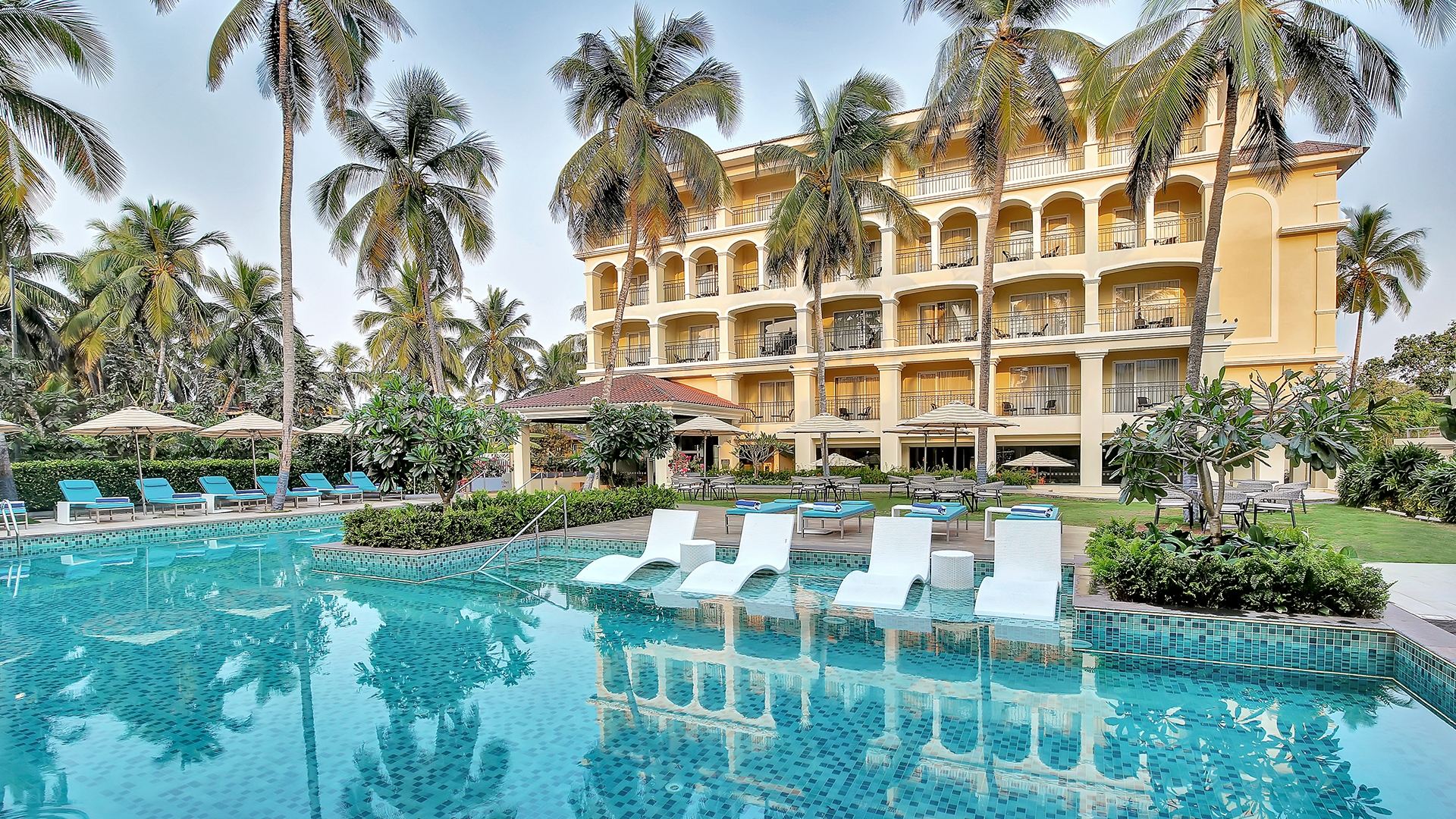 Oasis-style pool surrounded by palm trees at Holiday Inn Goa Candolim.