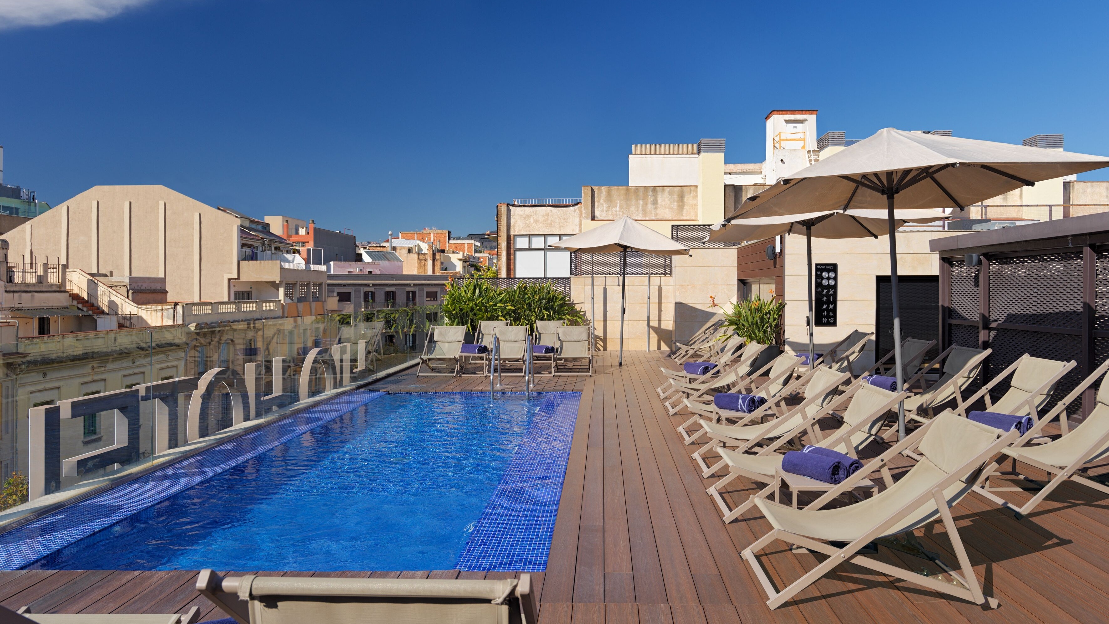 Rooftop pool with sun loungers at Barcelona boutique art hotel