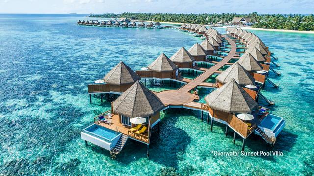 Overwater villas at Mercure Maldives Kooddoo Resort in vivid blue ocean.