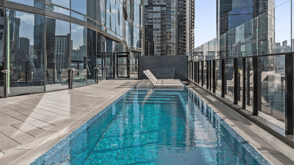 Rooftop heated pool at Melbourne Peppers Apartments with city views.