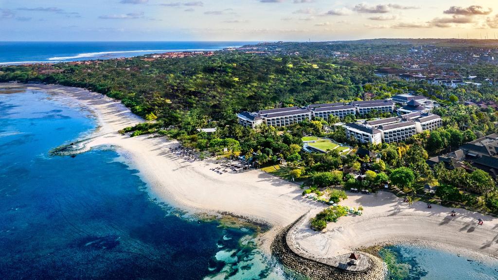 Aerial view of Sofitel Bali Nusa Dua Beach Resort beside a pristine coastline.