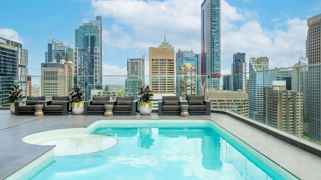 Rooftop pool overlooking Sydney skyline at Pullman Hyde Park Hotel.