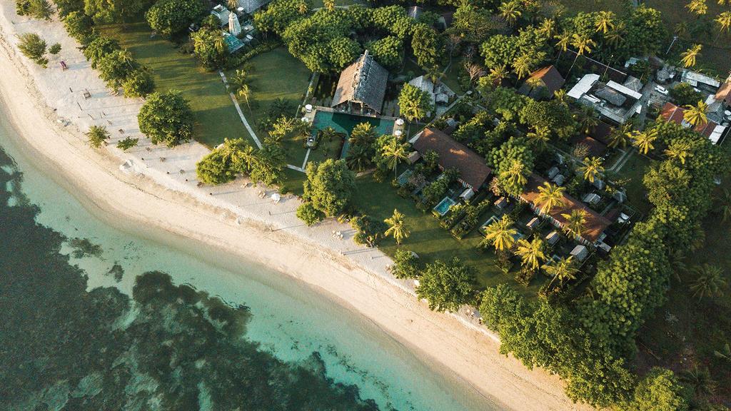Aerial view of Hotel Tugu Lombok on Sire Beach with lush greenery.