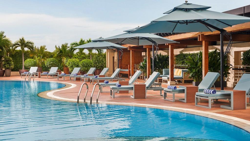 Outdoor pool with sun loungers at New World Saigon Hotel.  