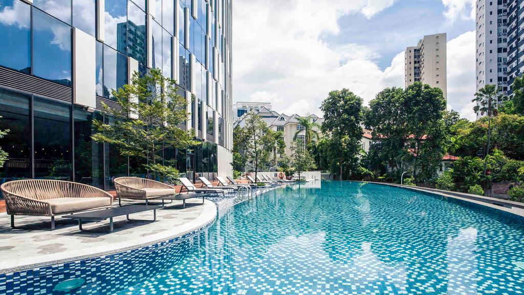 Infinity pool at a luxury hotel with lush surroundings in Singapore.