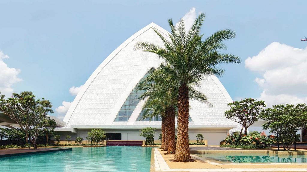Mövenpick Kuala Lumpur hotel with outdoor pool and modern architecture.