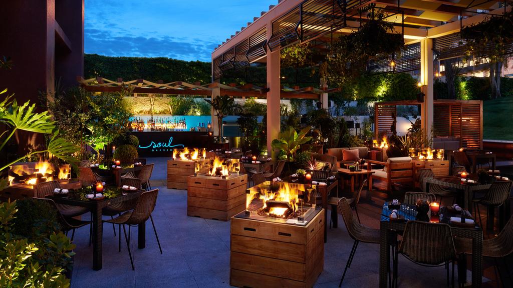 Stylish outdoor seating area at Soul Garden, with fire features and lush greenery.