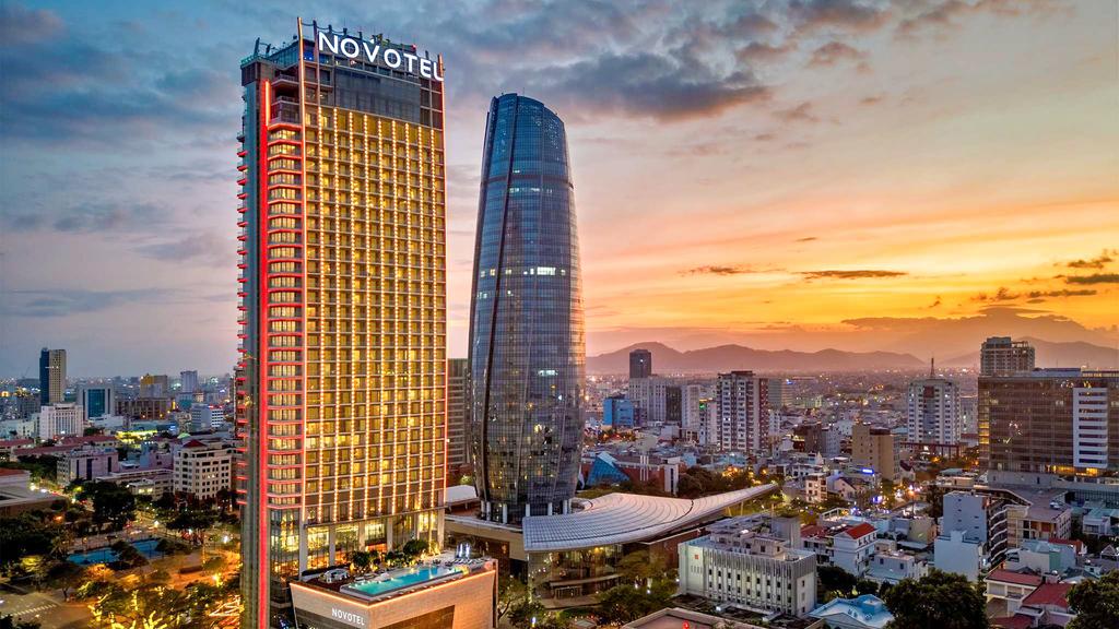 Vietnam riverfront hotel in Da Nang with rooftop pool at sunset.