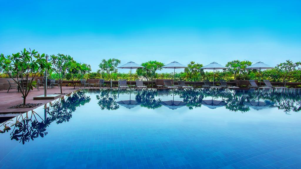 Outdoor pool at Crowne Plaza Ahmedabad with panoramic city views.