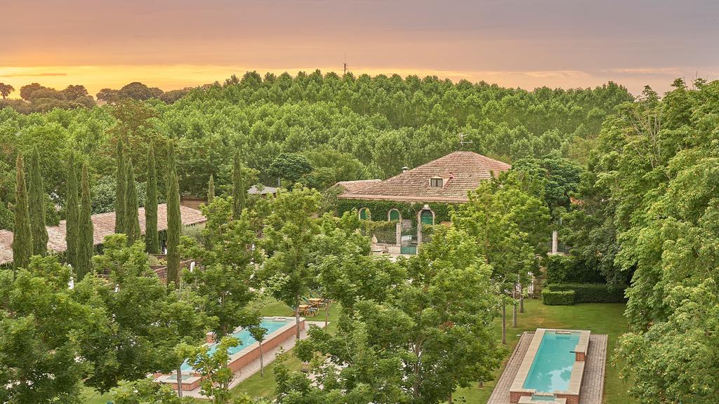 Hacienda Zorita set amidst lush vineyards at sunset, featuring a serene pool.