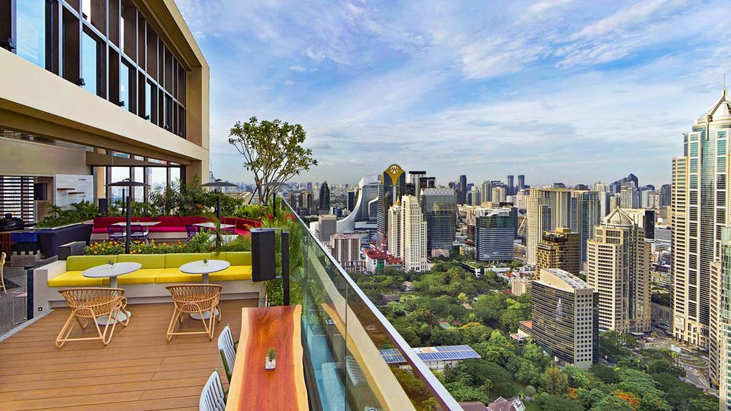 Rooftop view from Kimpton Maa-Lai Bangkok overlooking Bangkok's skyline and greenery.