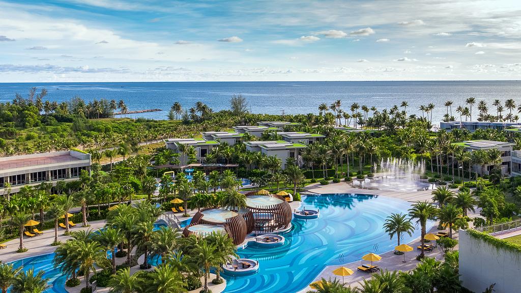 Aerial view of Pullman Phu Quoc resort with lagoon pool and ocean backdrop.