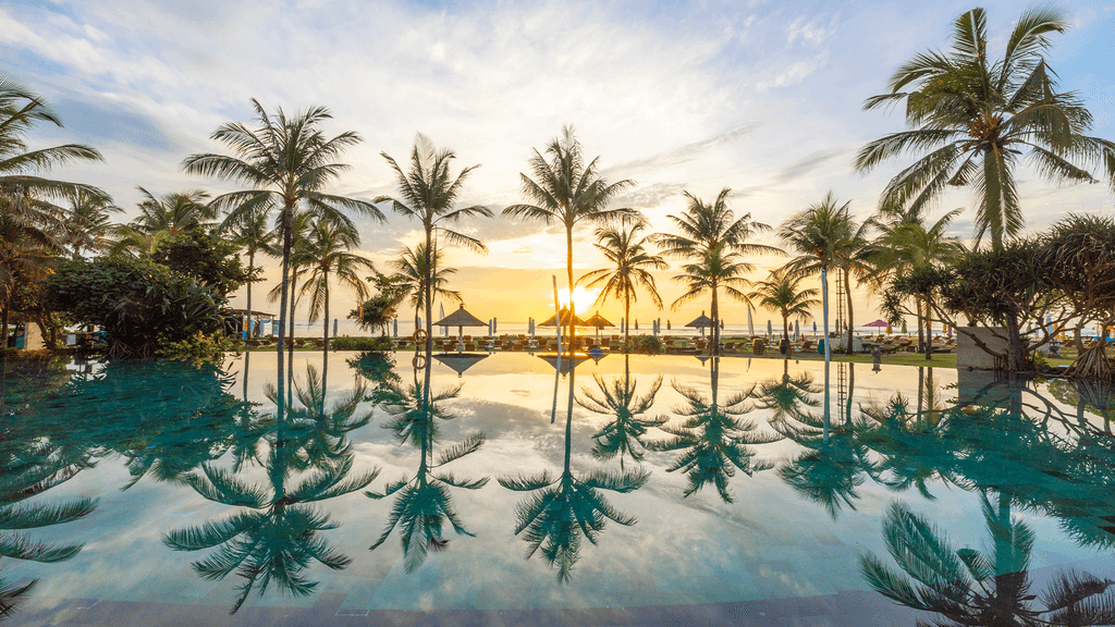 Sunrise view at the pool with palm trees at Ayodya Resort, Nusa Dua, Bali.  