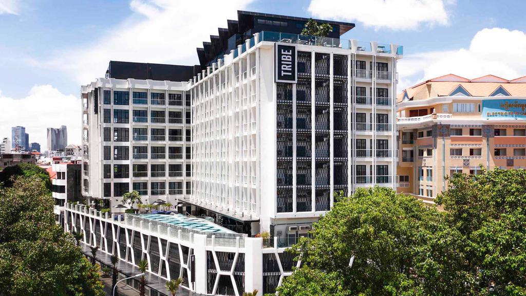 Exterior view of a chic hotel in Phnom Penh with a rooftop pool.