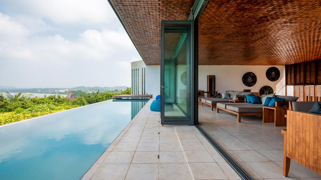 Infinity pool with lounge area overlooking jungle and Weligama Bay.