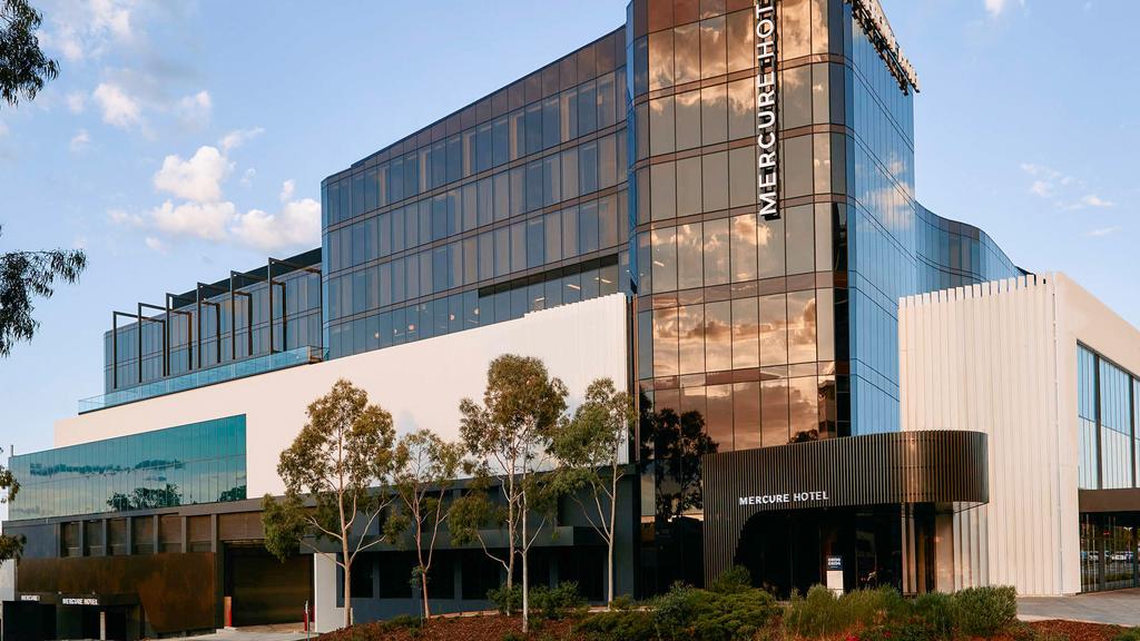 Exterior of Mercure Hotel in Melbourne with modern glass facade.