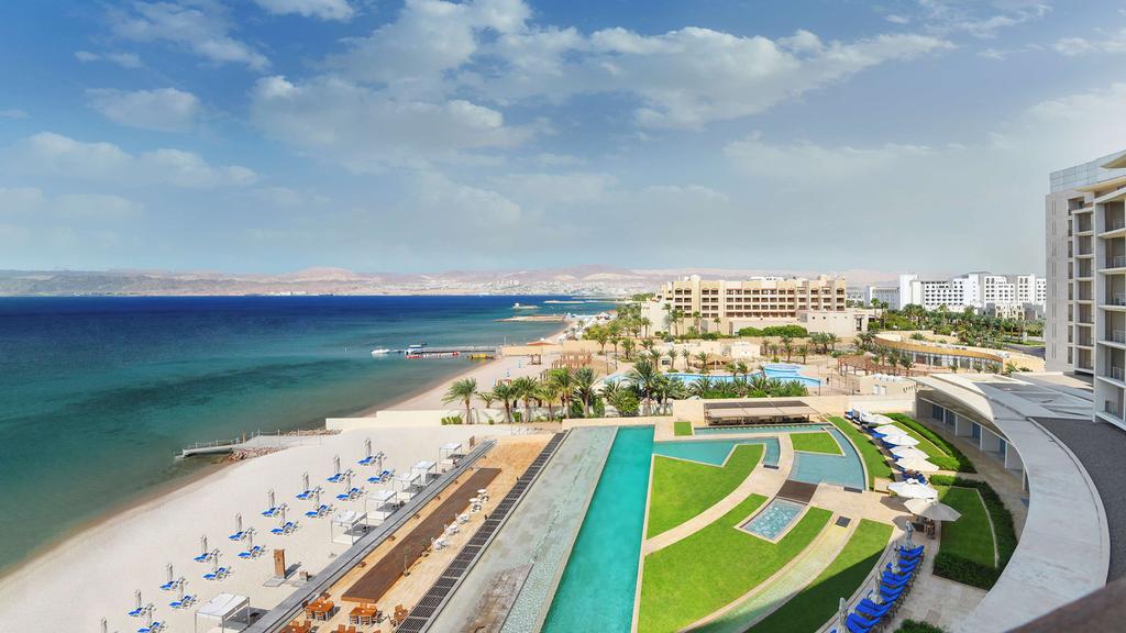 View from Kempinski Hotel Aqaba overlooking the Red Sea and white sandy beach.