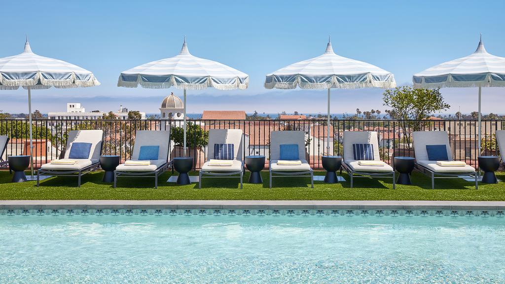 Rooftop pool with sun loungers and parasols at Kimpton Canary Hotel.