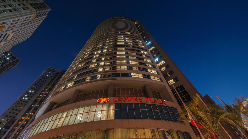 Crowne Plaza Manila Galleria skyscraper in the heart of Ortigas Center at dusk.