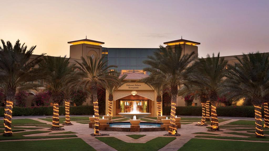 Elegant entrance of Djibouti Palace Kempinski adorned with palm trees.