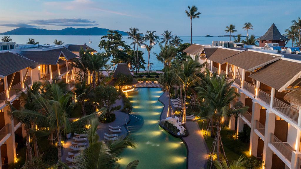 A beachfront resort in Koh Samui with palm trees and a pool.