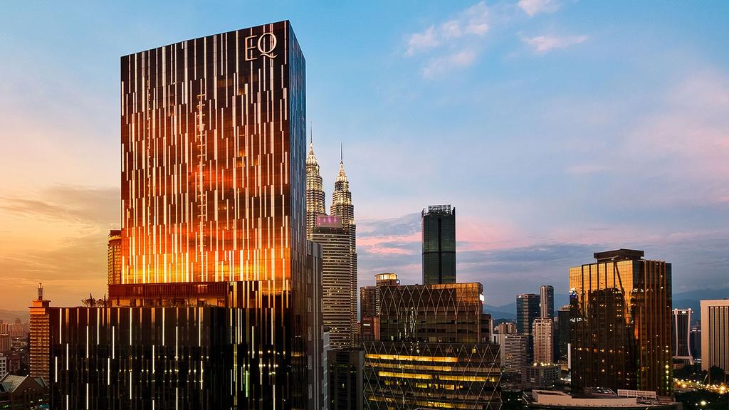 Skyline view of KL with EQ Kuala Lumpur and Petronas Towers at sunset.