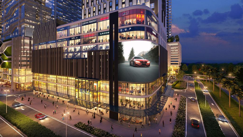 Modern hotel exterior with shops and illuminated sign at night.