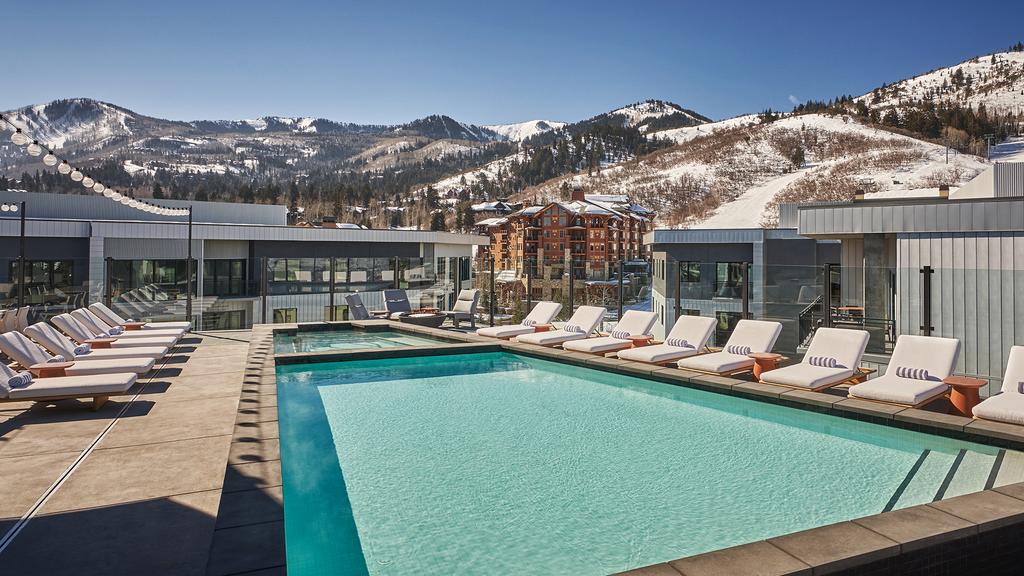 Luxury ski resort with pool and mountain views.