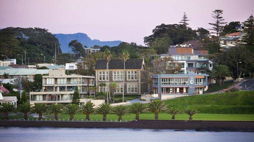 View of Kiama Harbourside Hotel with lush surroundings and palm trees.