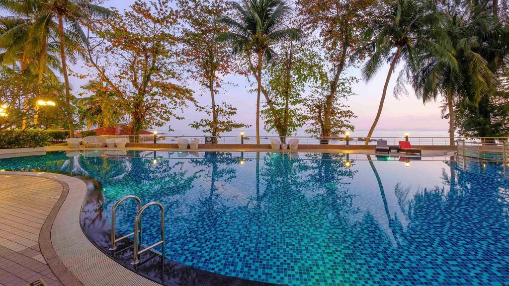 Outdoor pool at a Penang beachfront resort with sea views.