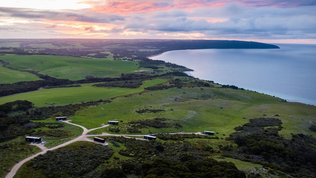 Aerial view of cabins on Kangaroo Island with ocean and wilderness.