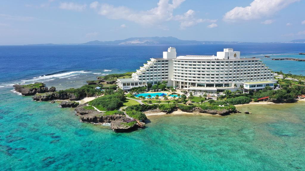 Aerial view of Okinawa beachfront resort with private beach and clear waters.