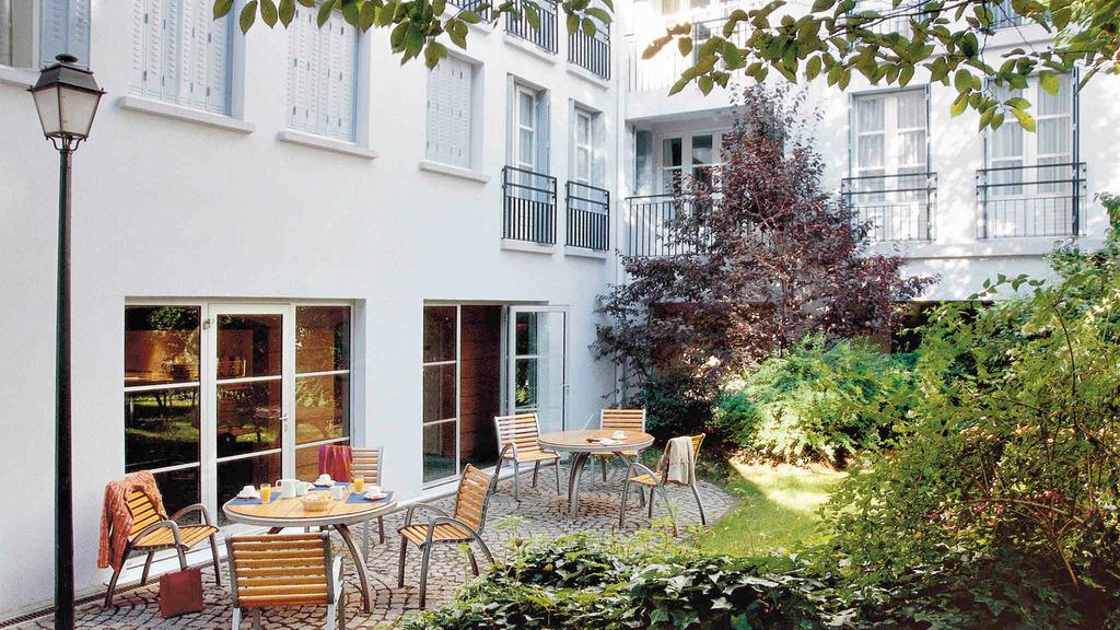 Quaint interior garden of Paris Montmartre apartment with outdoor seating.
