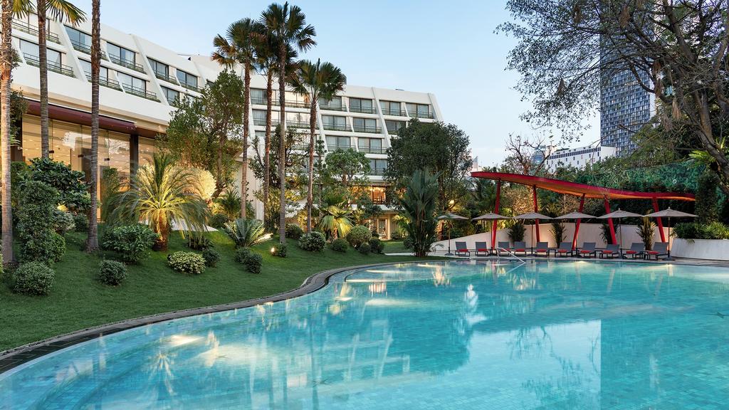 Luxurious Mövenpick BDMS Wellness Resort Bangkok with tropical gardens and a tranquil pool.