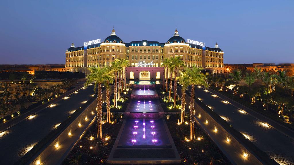 Elegant night view of the Kempinski Palace Cairo with illuminated gardens.