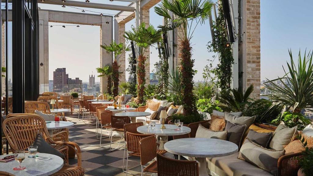 Stylish rooftop bar with panoramic city views and lush greenery.