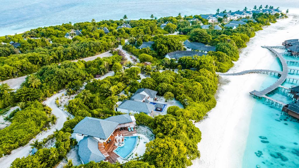Aerial view of luxurious beachfront villas on Maldives' Dhonakulhi Island.