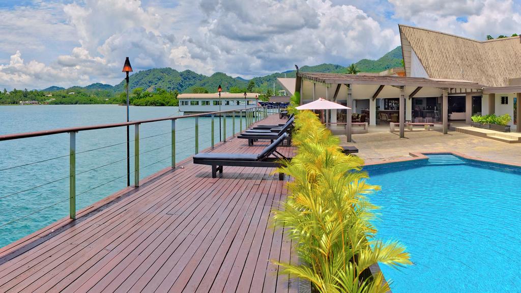 Waterfront view of Fiji Novotel Lami Bay with pool and sun loungers.