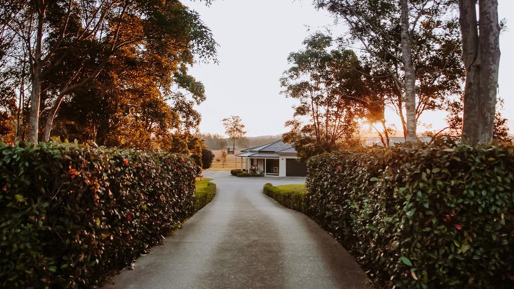 Driveway leading to a secluded garden estate at sunset.