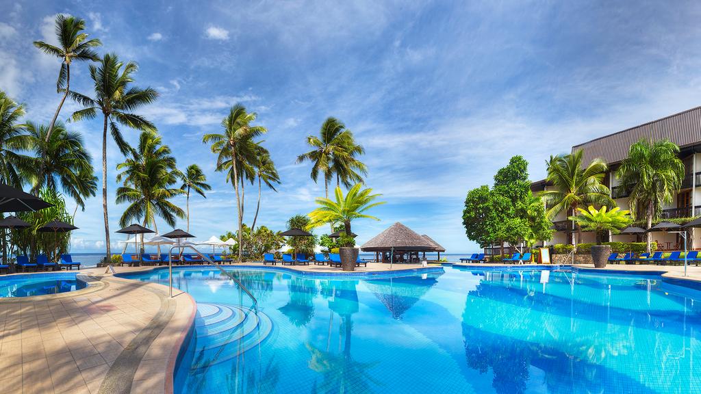 Luxurious pool at Warwick Fiji surrounded by palm trees on Fiji's Coral Coast.