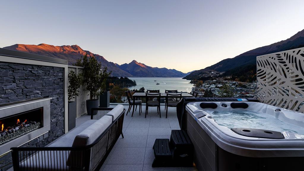 Terrace with spa overlooking Lake Wakatipu at a luxury boutique hotel.