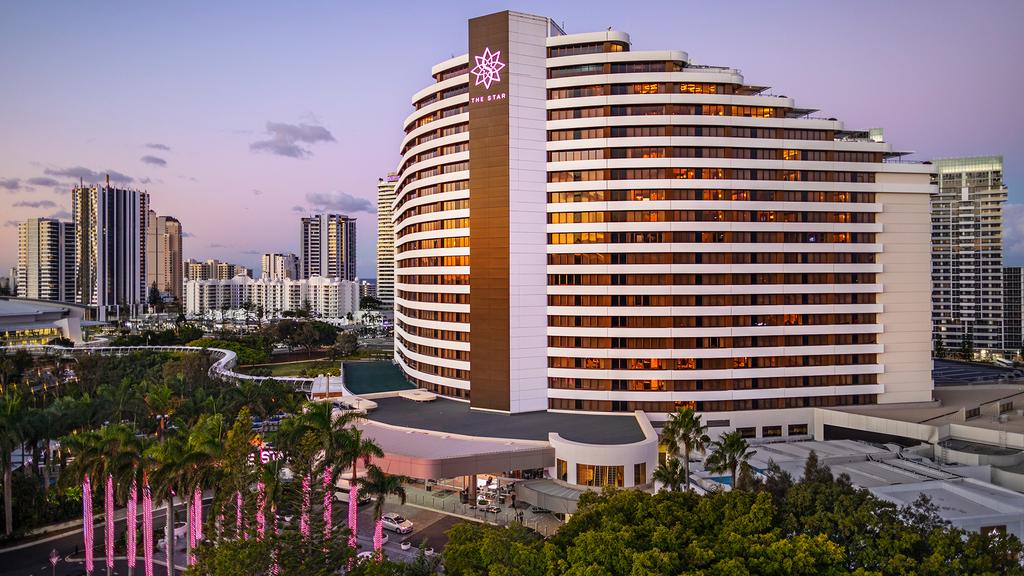The Star Grand at The Star Gold Coast at dusk with city skyline.