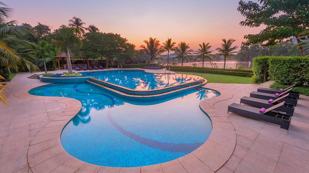 A scenic poolside view at Crowne Plaza Kochi during sunset.
