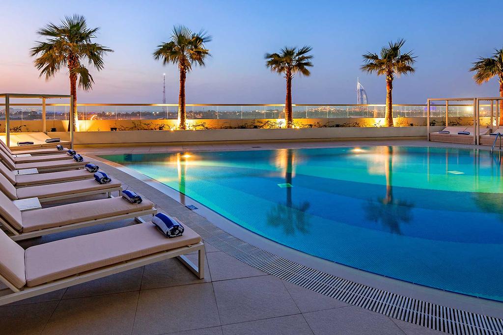 Rooftop pool with Burj Al Arab views at Dubai apartment retreat.