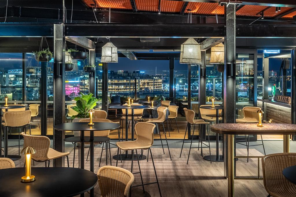 Rooftop bar at QT Auckland with city skyline views.