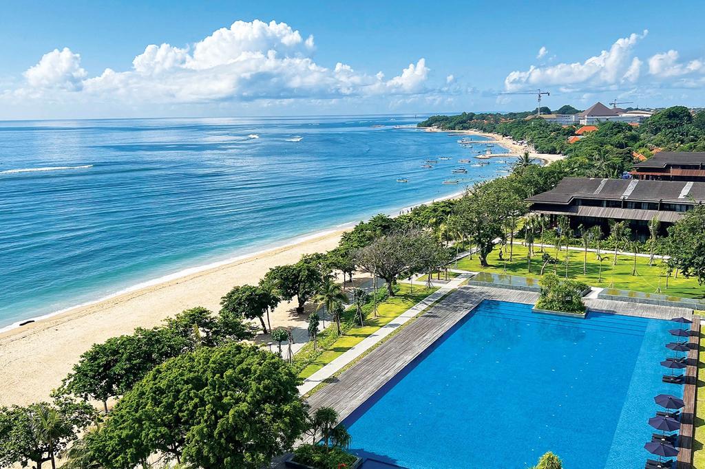 A beachfront Bali hotel with a large pool and ocean views.
