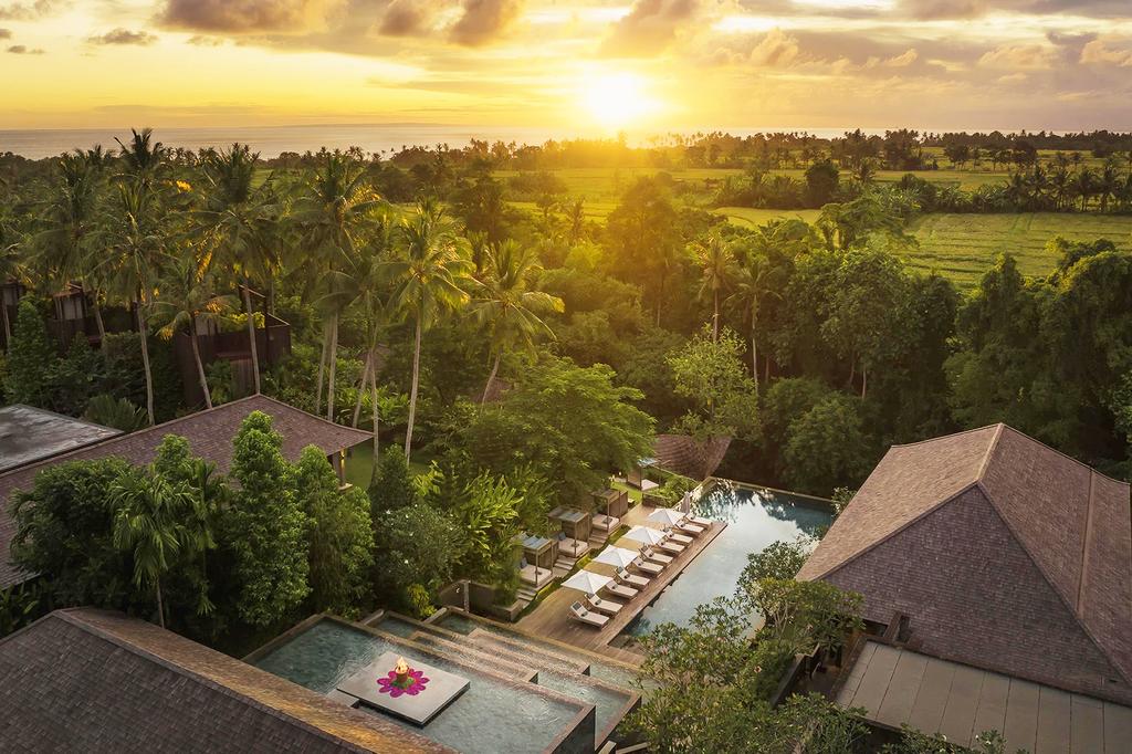 Aerial view of Nirjhara luxury Bali jungle villas at sunset.