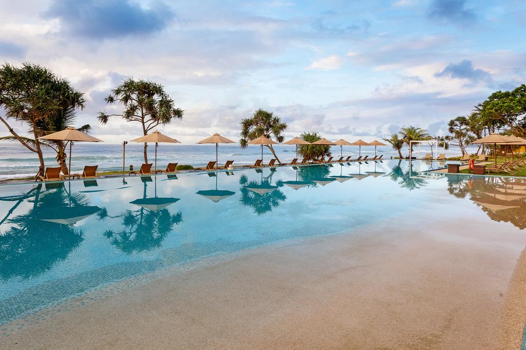Luxurious poolside view of the Indian Ocean at The Fortress Resort & Spa in Sri Lanka.