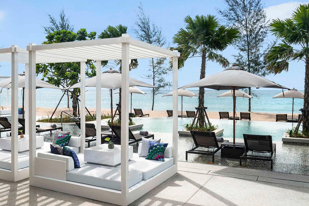 Beachfront pool area with cabanas at Pullman Khao Lak Resort.