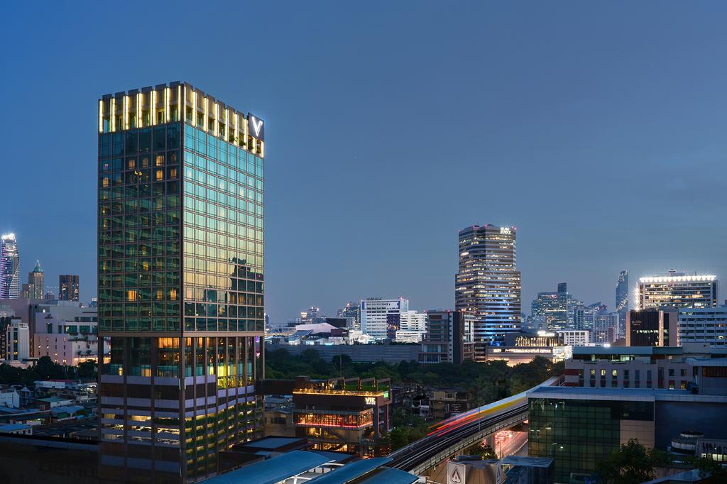 Skyline view of VIE Hotel Bangkok with cityscape at dusk. 
